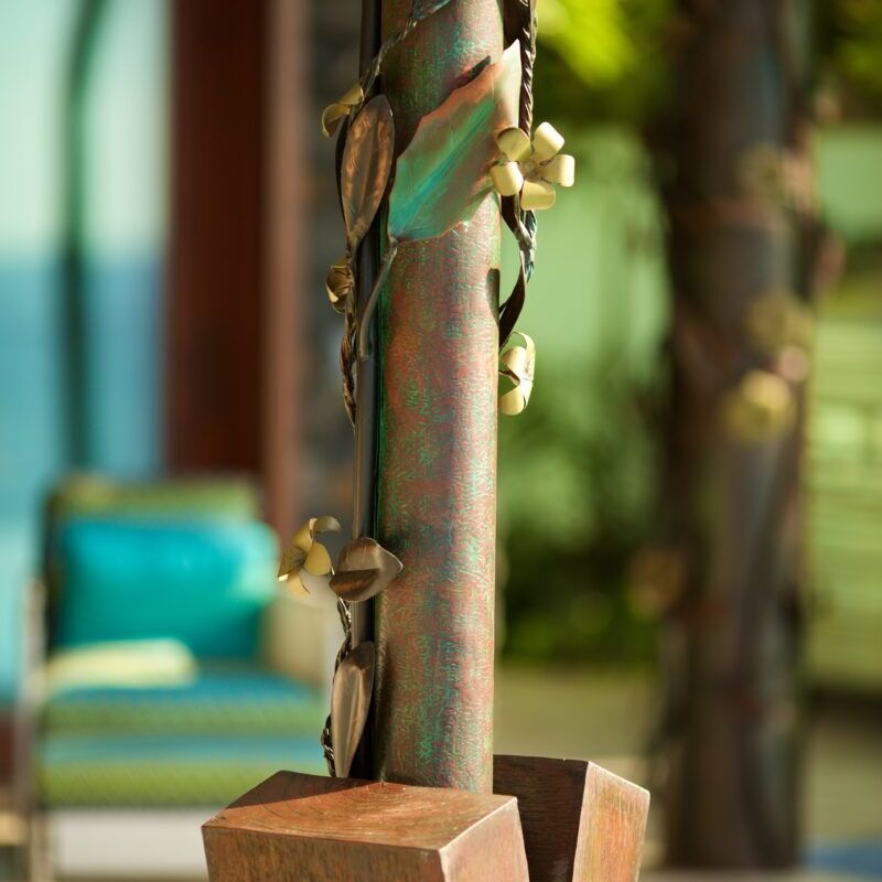 Close-up of a rustic wooden wind chime hanging outdoors.
