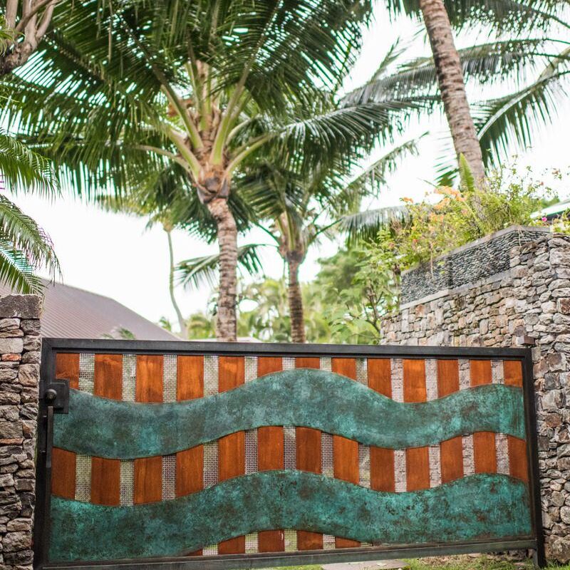A decorative garden gate with a wave pattern made of metal and wood.