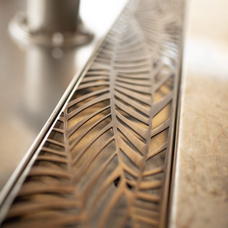 Close-up of a decorative metal strip with a leaf pattern.
