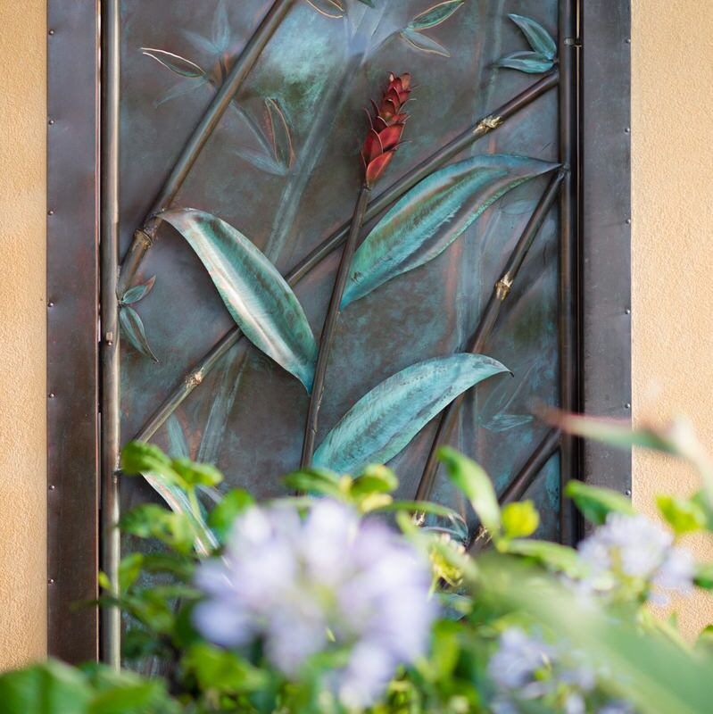 Decorative metal wall art with bird and leaf design.