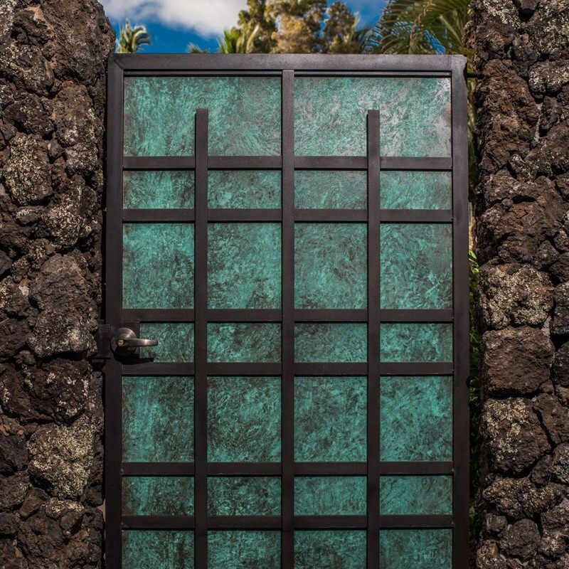 Rustic green metal door set in a stone wall.