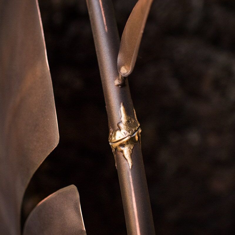 Close-up of a golden ring on a metallic spear shaft.