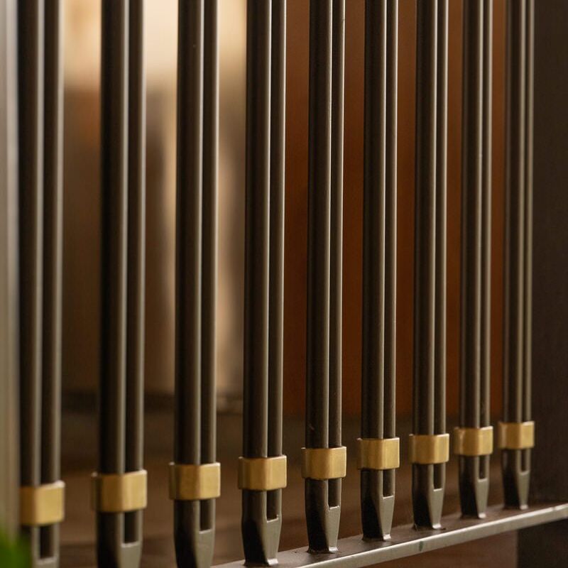 Close-up of polished organ pipes arranged in a row.