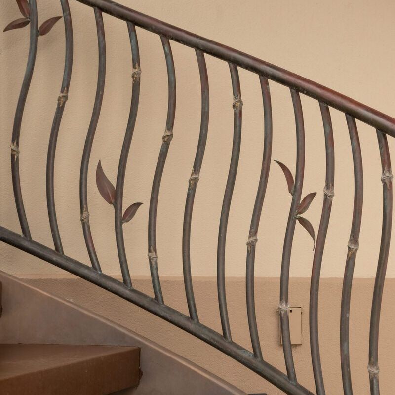 Decorative metal railing with leaf designs on a staircase.