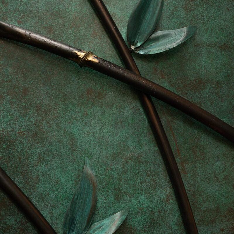 Close-up of dark wooden sticks and green leaves on a textured surface.