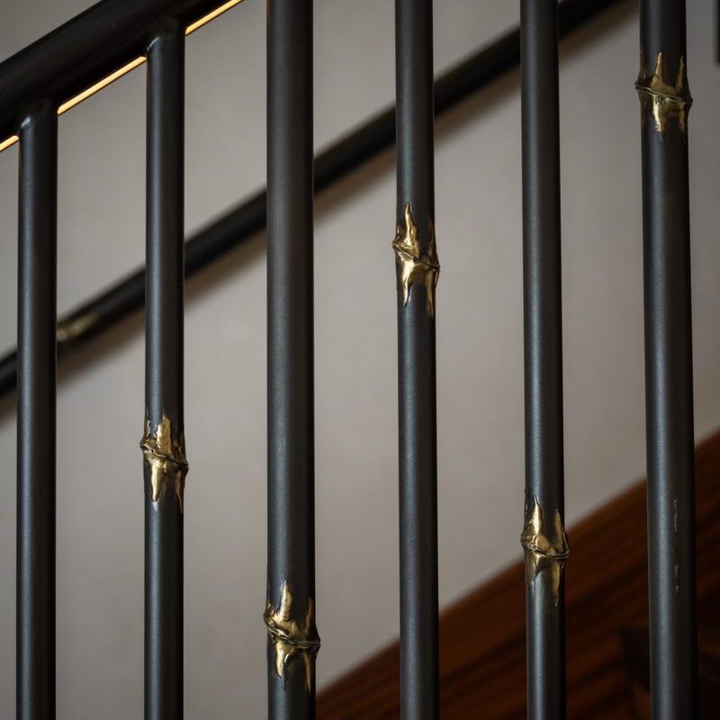 Decorative black metal railing with gold accents indoors.