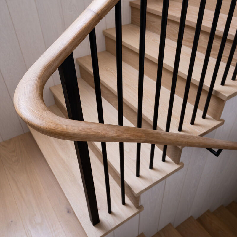 Curved oak handrail with black balusters